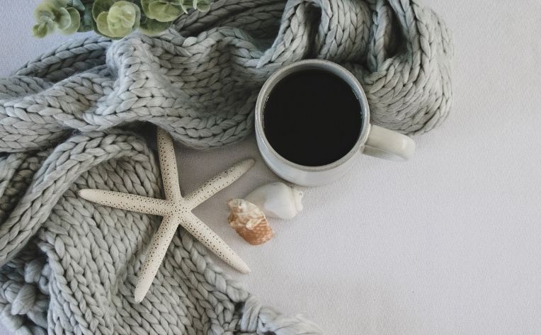 hygge with a scarf, coffee and sea shells